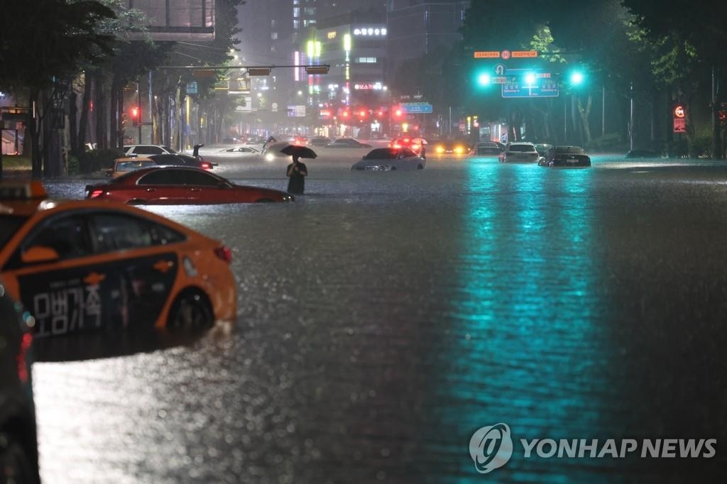 大雨で道路が冠水したソウル市江南区の繁華街付近＝８日、ソウル（聯合ニュース）