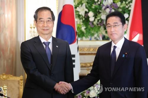 会談で握手を交わす韓首相（左）と岸田首相＝２８日、東京（聯合ニュース）