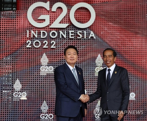 主要２０カ国・地域首脳会議（Ｇ２０サミット）の議長を務めるインドネシアのジョコ大統領（右）と握手する尹大統領＝１５日、バリ島（聯合ニュース）