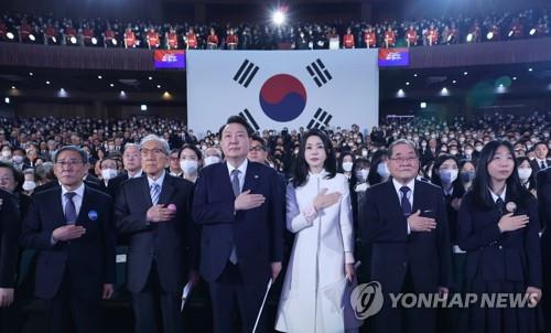 式典で国旗に敬礼する尹大統領夫妻＝１日、ソウル（聯合ニュース）