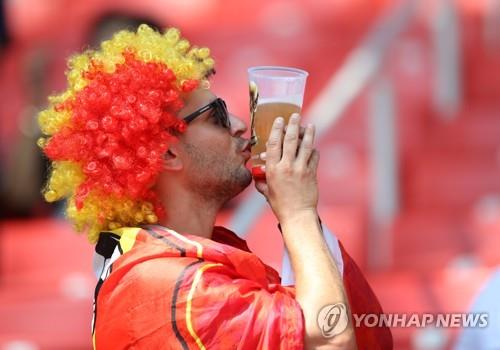 맥주잔을 들고 월드컵 경기를 관전하는 축구팬