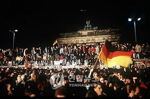 1989년 11월 베를린 장벽 붕괴 후 장벽 위에 올라가 환호하는 동서독 시민들 [연합뉴스 자료사진]