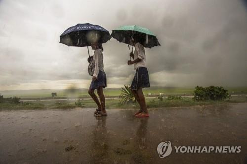 지난 9일(현지시간) 마다가스카르의 수도 안타나나리보에서 우산을 들고 걸어가는 학생들[AP=연합뉴스]