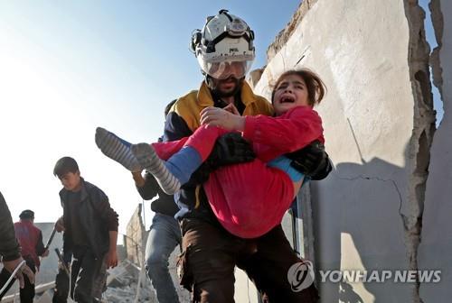 정부군의 공격으로 부상한 어린이를 구조하는 시리아 반군 지역 민간구호대