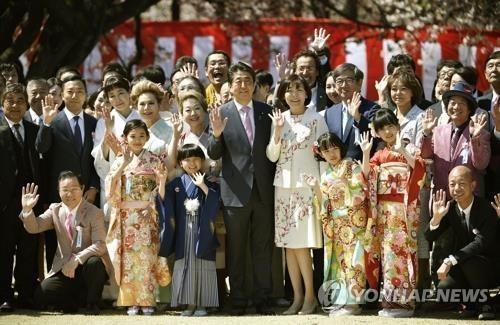 아베 신조 총리가 2019년 4월 13일 도쿄 도심 공원인 '신주쿠 교엔'에서 열린 '벚꽃을 보는 모임' 행사에서 참석자들과 기념사진 촬영에 응하고 있다. [교도=연합뉴스 자료사진]