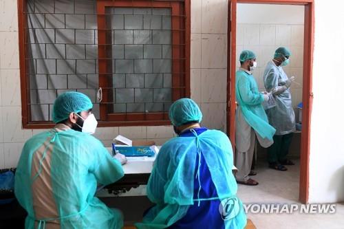 파키스탄 카라치의 의료 센터에서 코로나19 검사를 진행 중인 의료 관계자들. [AFP=연합뉴스]