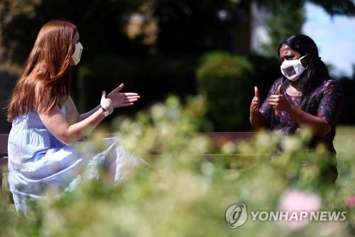 투명한 마스크를 쓴 사람들이 수화로 대화를 하고 있다. [로이터=연합뉴스 자료사진]