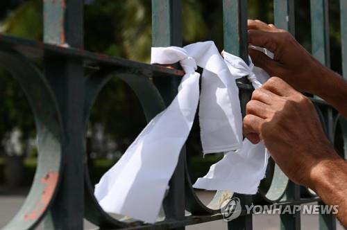 무슬림 코로나19 사망자에 대한 강제 화장 집행에 항의하는 스리랑카인이 화장장 출입구에 흰 리본을 묶는 모습. [AFP=연합뉴스]