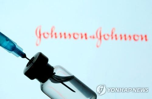 A syringe and vial with the Johnson & Johnson company logo in the background