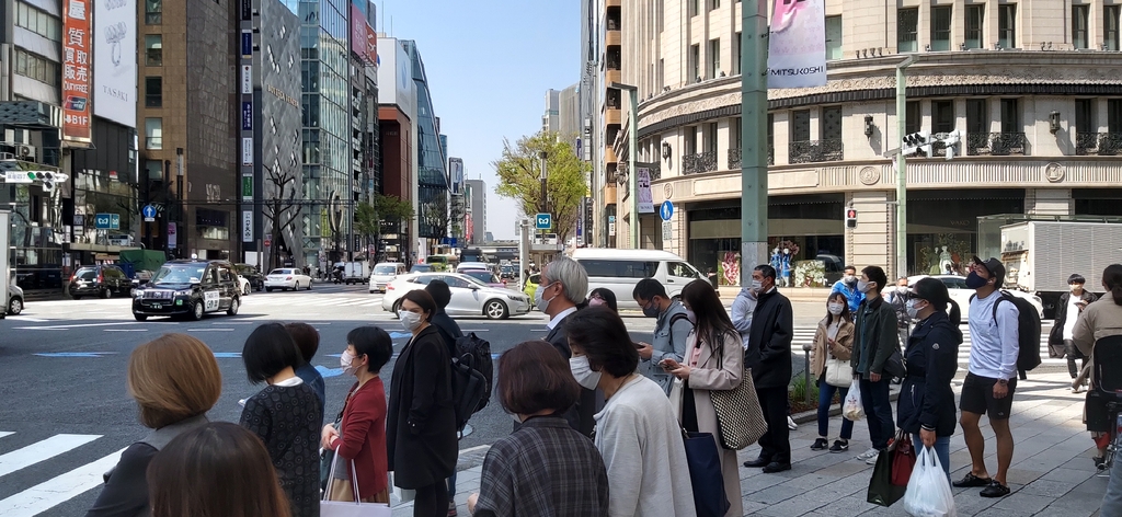 (도쿄=연합뉴스) 26일 낮 도쿄 긴자(銀座) 거리의 횡단보도에서 마스크를 쓴 사람들이 신호가 바뀌기를 기다리고 있다.