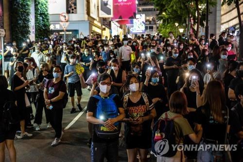 톈안먼 민주화시위 32주년을 맞은 4일 저녁 홍콩 코즈웨이베이에서 시민들이 일제히 휴대전화 손전등을 켜며 희생자들을 추모했다.[AFP=연합뉴스] 