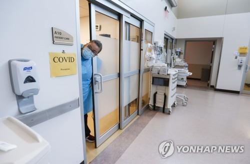 7월 미국 미주리주 콕스헬스 응급실의 코로나19 환자 병실에서 한 간호사가 고개를 내밀고 있다. [AP=연합뉴스]