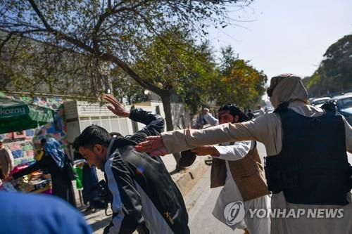  21일 카불에서 취재진을 폭행하는 탈레반 대원