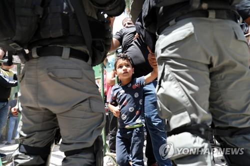 지난해 8월 헤브론에서 한 팔레스타인 소년이 이스라엘 경찰을 바라보는 모습
