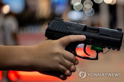 전미총기협회(NRA) 전시회에서 권총을 잡은 어린이