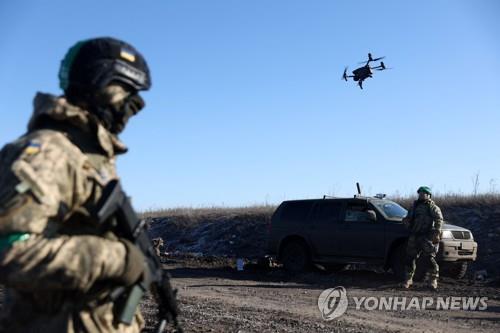 우크라이나 동부 격전지 바흐무트 인근을 비행하는 드론과 우크라이나 병사들 [AFP 연합뉴스 자료사진. 재판매 및 DB 금지]