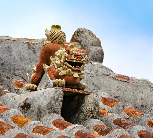 쓰보야 아치문 도자기 거리의 붉은 기와 지붕 위에 류큐 왕국의 수호 동물인 시사가 놓여 있다. [사진/진성철 기자] 