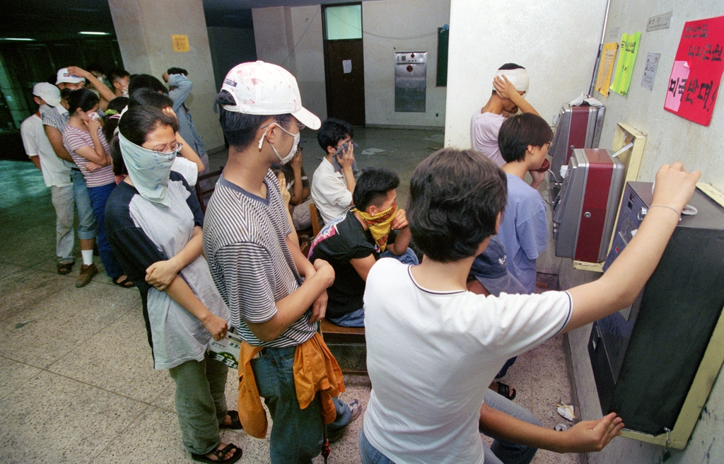 한 대학 학생회관에서 시위를 벌이던 학생들이 공중전화로 통화하고 있다. 1996년 [연합뉴스 자료사진]