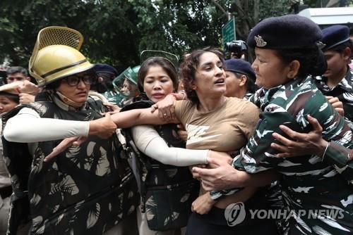 지난달 경찰에 의해 끌려가는 인도 레슬링선수 비네시 포가트(가운데 갈색 셔츠)