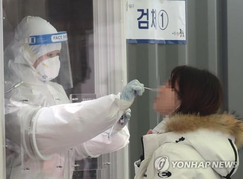 Una trabajadora médica recolecta muestras, el 15 de febrero de 2021, en una clínica provisional de exámenes del nuevo coronavirus en la Estación de Seúl.