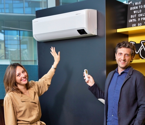 La foto proporcionada, el 2 de agosto de 2021, por Samsung Electronics Co., muestra a empleados de la firma presentando su aparato de aire acondicionado WindFree, en un salón de exhibiciones, en Italia. (Prohibida su reventa y archivo)