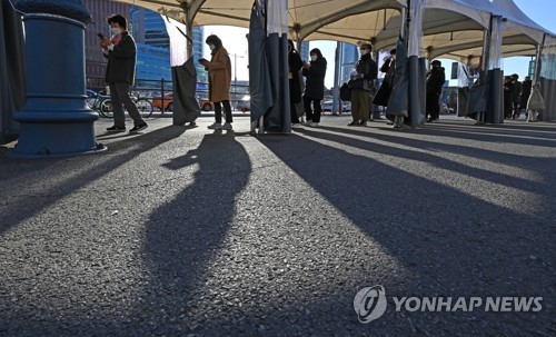 Las personas esperan en fila para someterse a las pruebas del nuevo coronavirus, el 26 de noviembre de 2021, en una clínica provisional frente a la Estación de Seúl. 