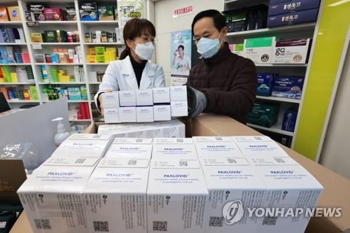 Una farmacéutica recibe cajas de la píldora oral para el tratamiento del coronavirus Paxlovid, del gigante farmacéutico estadounidense Pfizer Inc., el 14 de enero de 2022, en una farmacia de Seúl.
