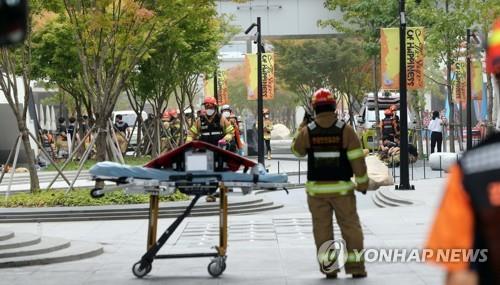 En la foto, los bomberos se encuentran realizando una búsqueda de las personas desaparecidas, tras un incendio ocurrido, el 26 de septiembre de 2022, en el centro comercial Hyundai Premium Outlet, en Daejeon, a 160 kilómetros al sur de Seúl.