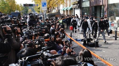Los funcionarios del Servicio Nacional Forense y agentes de policía inspeccionan, el 31 de octubre de 2022, el sitio de la estampida mortal en el barrio de Itaewon, en Seúl.