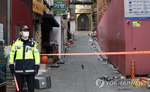 La foto, tomada el 3 de noviembre de 2022, muestra a un agente de policía parado frente al sitio donde ocurrió la estampida mortal, el 29 de octubre, en el barrio de Itaewon, en el centro de Seúl.
