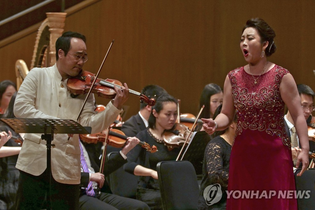 In this Associated Press photo, South Korean violinist Won Hyung-joon (L) and North Korean soprano Kim Song-mi perform at the Shanghai Oriental Arts Center with the Shanghai City Symphony Orchestra on May 12, 2019. (Yonhap)