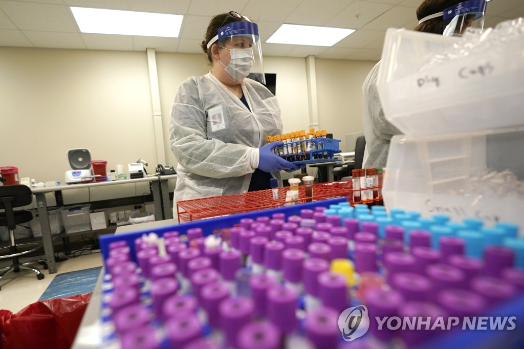  지난달 28일 텍사스 휴스턴에 있는 한 바이오기업의 직원이 코로나19 항체 검사용 혈액 검체를 다루고 있다. 