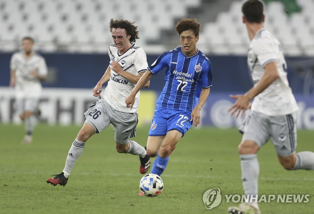 In this Associated Press photo, Lee Chung-yong of Ulsan Hyundai FC (R) battles Jay Barnett of Melbourne Victory for the ball during their round of 16 match at the Asian Football Confederation Champions League at Education City Stadium in Al-Rayyan, Qatar, on Dec. 6, 2020. (Yonhap)