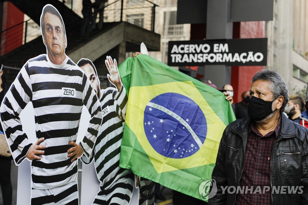 19일(현지시간) 브라질 상파울로에서 시위대가 자이르 보우소나루 대통령의 신종 코로나바이러스 감염증(코로나19) 대응을 비판하고 있다 [AP=연합뉴스]