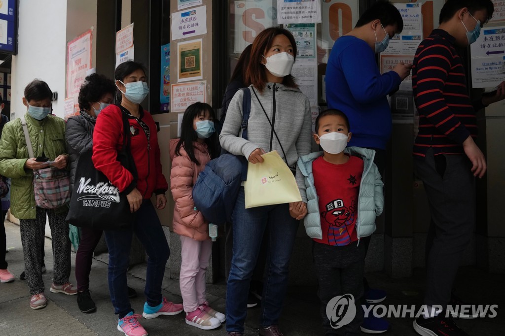 (AP=연합뉴스) 15일 홍콩에서 3∼11세 대상 시노백 백신 접종이 시작되자 부모들이 어린 자녀를 데리고 접종 센터를 찾은 모습. 