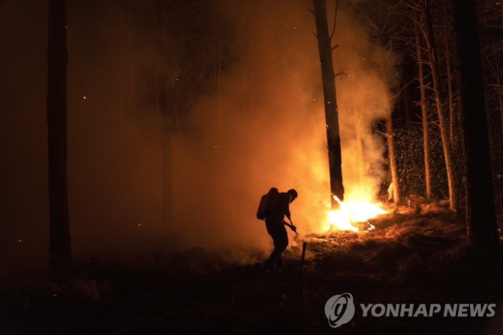 19일(현지시간) 아르헨티나 코리엔테스주 산불 현장에서 사투 벌이는 소방관