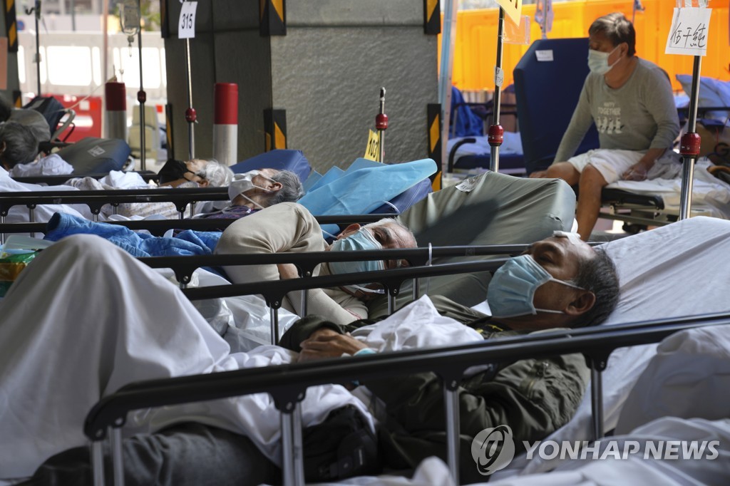 (AP=연합뉴스) 지난 2일 홍콩의 한 병원 바깥에서 코로나19 환자들이 침대에 누운 채 대기하는 모습. 2022.3.10.
