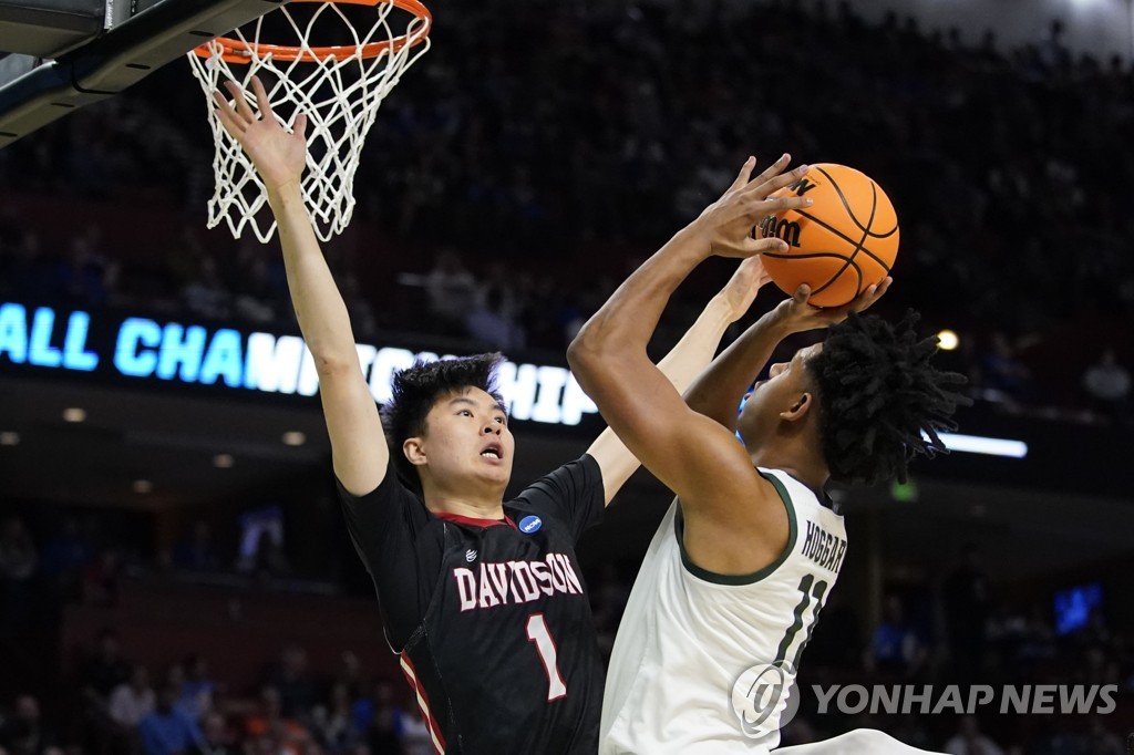 In this Associated Press photo, Lee Hyun-jung of the Davidson Wildcats (L) tries to block a shot attempt by A.J. Hoggard of the Michigan State Spartans during the first round game of the West Region in the National Collegiate Athletic Association Division I Men's Basketball Tournament at Bon Secours Wellness Arena in Greenville, South Carolina, on March 18, 2022. (Yonhap)