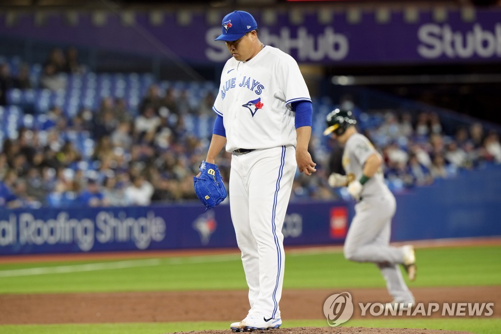 In this Canadian Press photo via the Associated Press, Toronto Blue Jays' starter Ryu Hyun-jin (L) reacts to a home run by Sean Murphy of the Oakland Athletics (R) during the top of the third inning of a Major League Baseball regular season game at Rogers Centre in Toronto on April 16, 2022. (Yonhap)