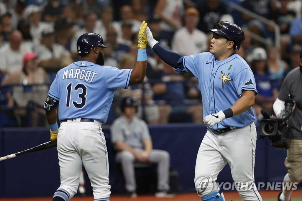 In this Associated Press photo, Choi Ji-man of the Tampa Bay Rays (R) celebrates with teammate Manuel Margot after hitting a solo home run against the New York Yankees during the bottom of the second inning of a Major League Baseball regular season game at Tropicana Field in St. Petersburg, Florida, on May 29, 2022. (Yonhap)