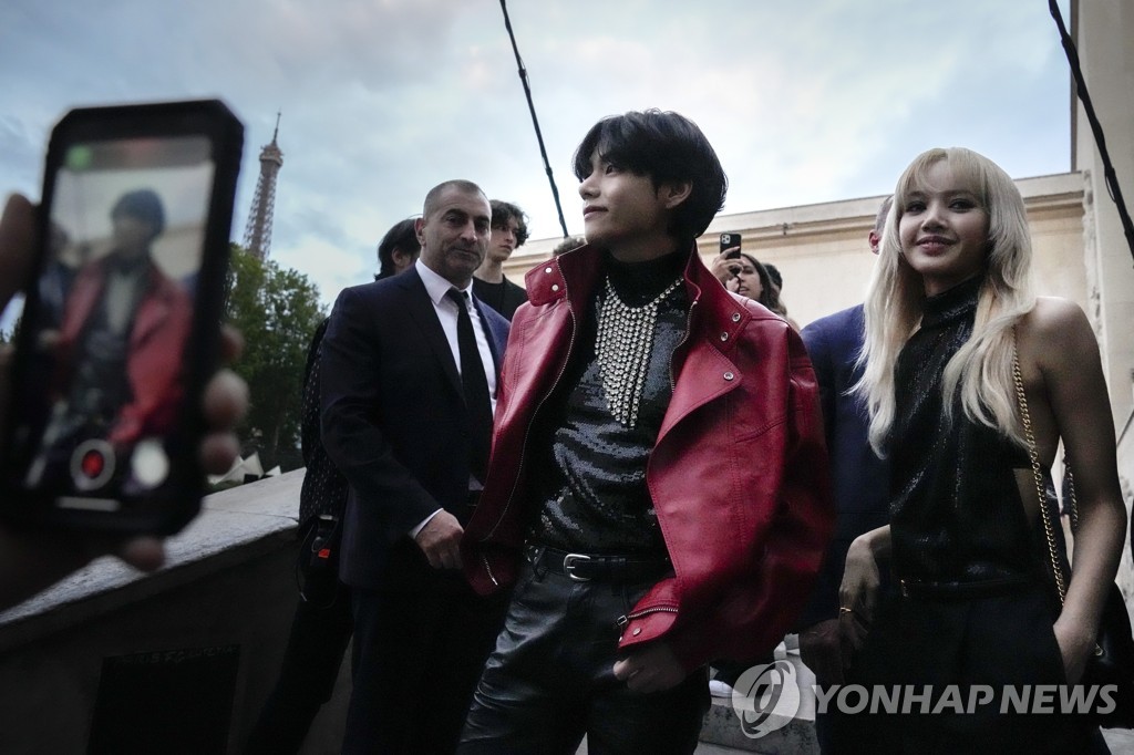 In this AP photo, K-pop stars V (C) of BTS and Lisa (R) of BLACKPINK attend a fashion show in Paris on June 26, 2022. (Yonhap)