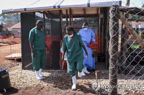 지난 9월 29일 우간다 에볼라 격리구역에서 고무 장화를 소독하고 떠나는 의료진