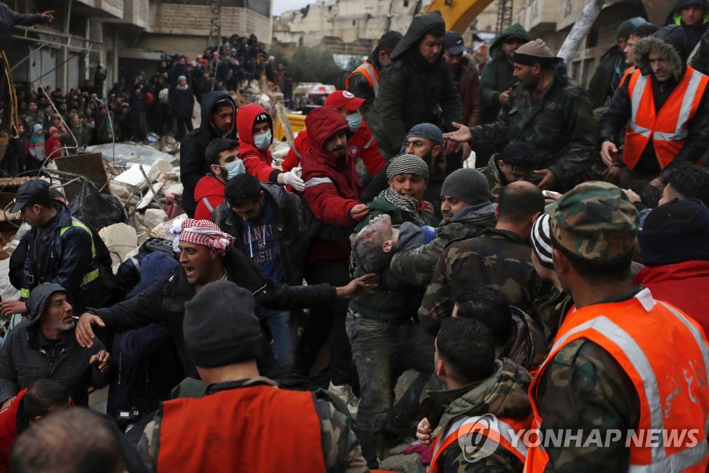 무너진 건물서 생존자 옮기는 시리아인들