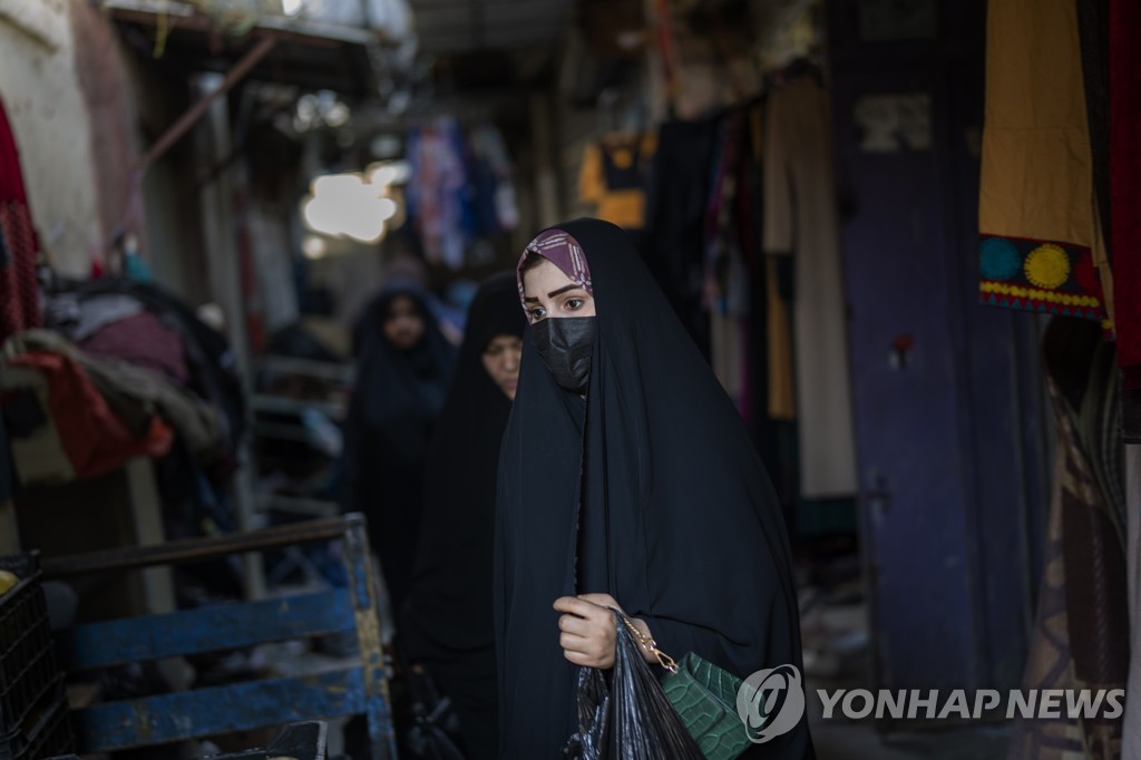 지난달 말 이라크 수도 바그다드 골목을 걷는 여성