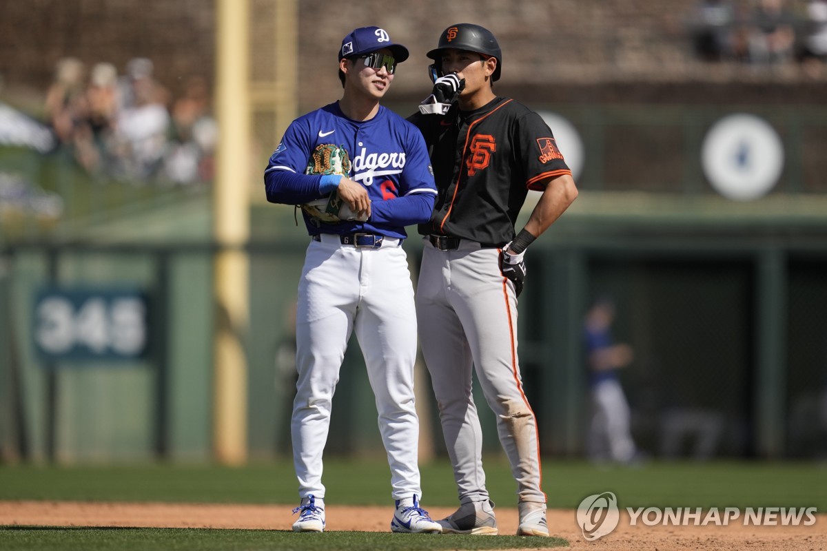 In this Associated Press photo, Kim Hye-seong of the Los Angeles Dodgers (L) chats with Lee Jung-hoo of the San Francisco Giants during a pitching change in their teams' Major League Baseball spring training game at Camelback Ranch in Glendale, Arizona, on March 1, 2025. (Yonhap)