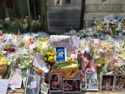 [촬영 윤고은]엘리자베스 2세 영국 여왕을 추모하기 위해 13일 홍콩 주재 영국 총영사관 앞에 놓인 꽃과 사진들.