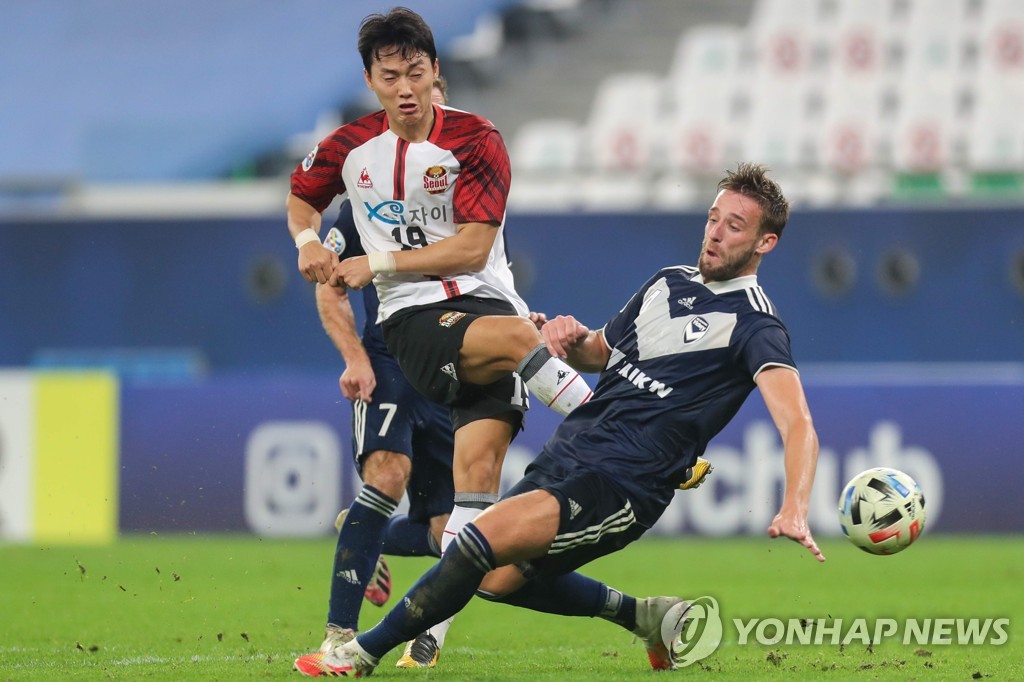 In this AFP photo, Yun Ju-tae of FC Seoul (L) takes a shot past Nicholas Ansell of Melbourne Victory in their Group E match at the Asian Football Confederation Champions League at Education City Stadium in Al Rayyan, Qatar, on Dec. 3, 2020. (Yonhap)