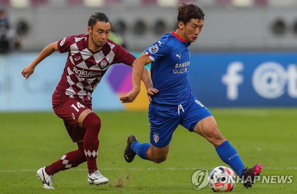 In this AFP photo, Kim Min-woo of Suwon Samsung Bluewings (R) dribbles past Takuya Yasui of Vissel Kobe during their Group G match at the Asian Football Confederation Champions League at Khalifa International Stadium in Doha on Dec. 4, 2020. (Yonhap)