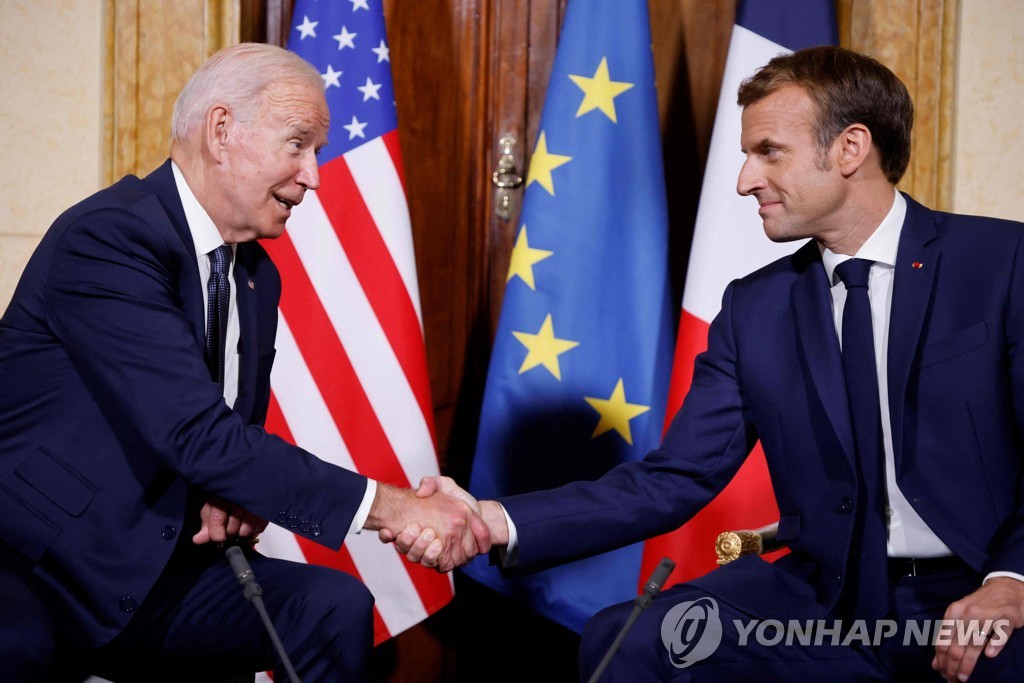 마크롱 프랑스 대통령(오른쪽)과 악수하는 바이든 미국 대통령(왼쪽)