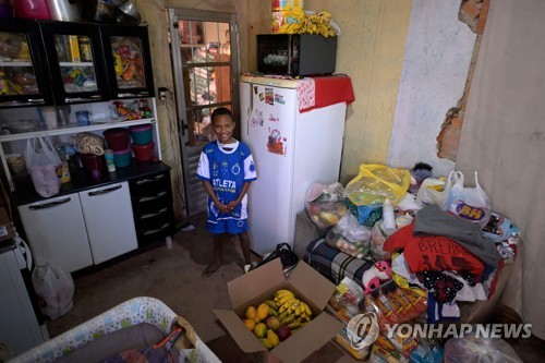 기부받은 식료품 등 보여주는 브라질 소년 미게우